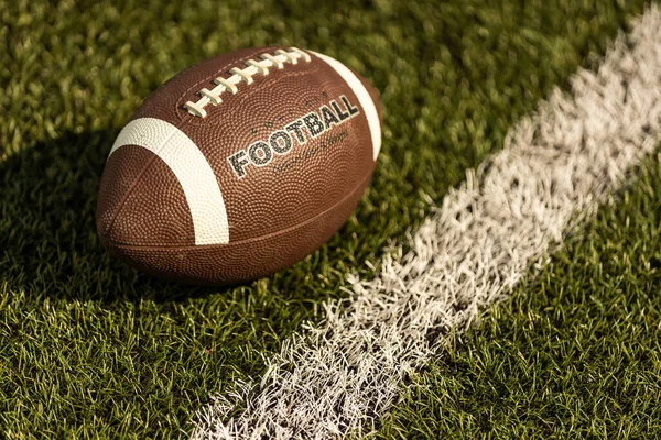 American football on football field background.