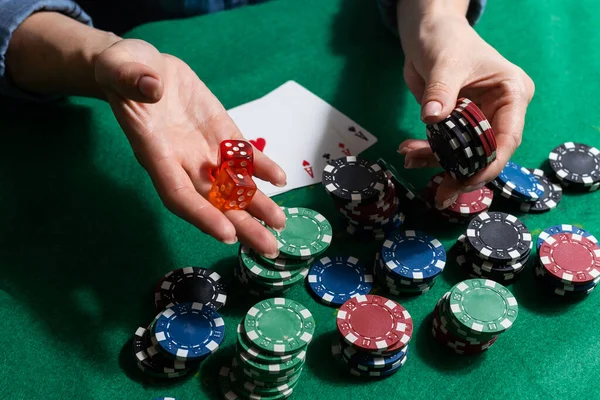 A woman plays in a casino. opening cards to raise bets. Against the background of chips. Poker victory.