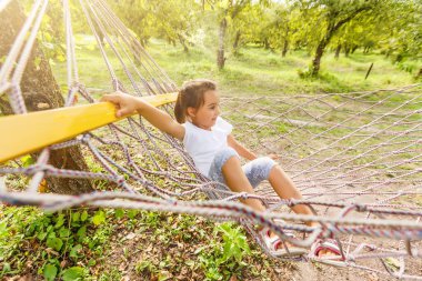 Yaz, tatil, hafta sonu kızı parlak bir hamakta yatıyor.