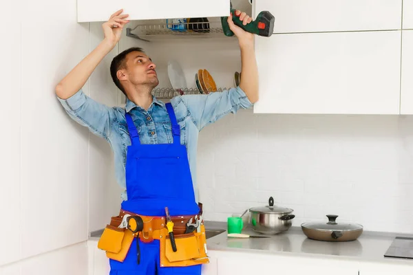Bir Adam Mavi Gömlekli Bir Tamirci Mutfakta Mobilya Monte Ediyor — Stok fotoğraf