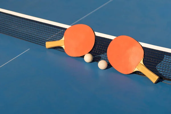 Ping pong table, rackets and balls.