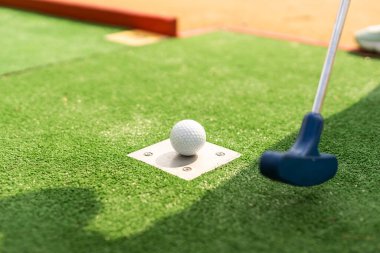 Mini golf oyun sırasında bir topa vurmak bir kulüp hazırlar.