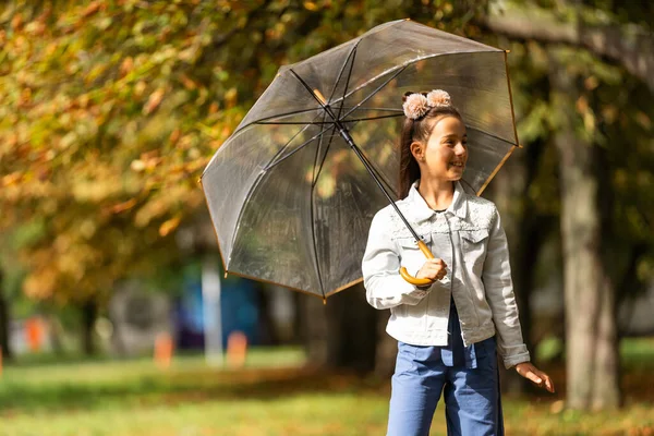 Kid playing out in the rain. Children with umbrella play outdoors in rain. autumn weather