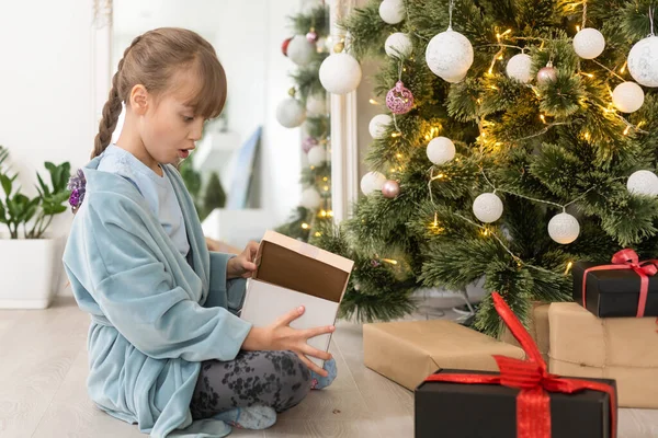 小さな子供の女の子が屋内でクリスマスツリーを飾る クリスマス前の朝 — ストック写真
