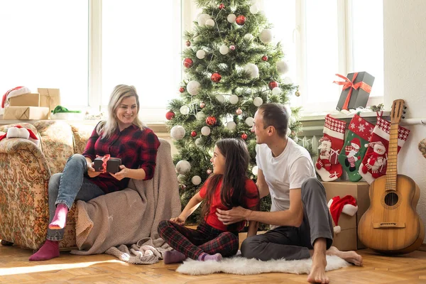 家庭でクリスマスを祝っている間若い幸せな家族 — ストック写真