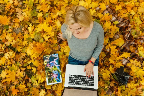 秋天公园里拿着手提电脑和相册的女人 — 图库照片
