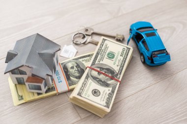 Bir sürü doların üzerinde araba ve mavi ev..