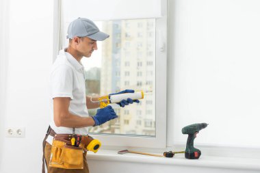 a repairman repairs, adjusts or installs metal-plastic windows in the apartment. glazing of balconies, loggias, verandas in house. production of double-glazed windows to individual sizes