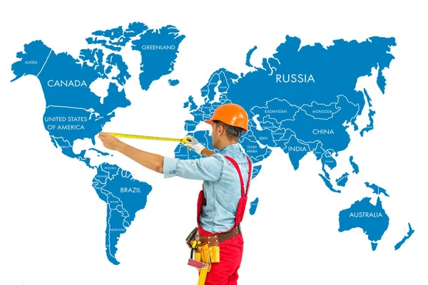Pracovník Pevném Klobouku Opatření Pravítkem Svět Mapa Pozadí — Stock fotografie