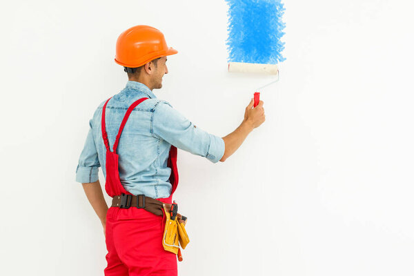 Room paint job. painter with a paint roller on a white background.