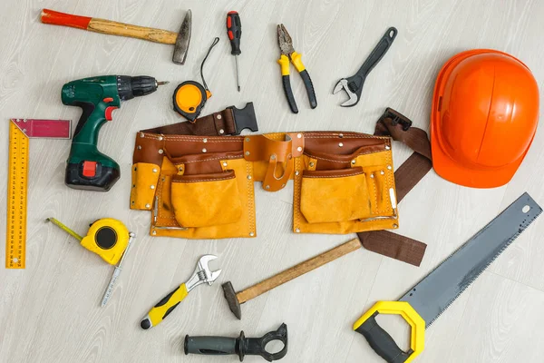 Mühendislik ürünü ahşap döşeme tesisatı. Köpük kaplamalı gri döşeme ve çeşitli marangozluk aletleri