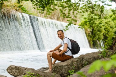 Turizm şelale arka plan Closeup yolculuk seyahat Trek kavramı Hiking omzuna seyahat sırt çantası askısı