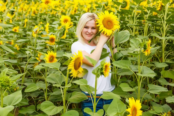 young beautiful woman between sunflowers