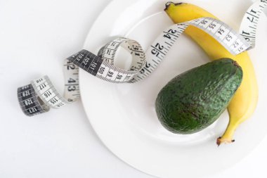 Beyaz bir tabakta mezura ve muz avokadosu..