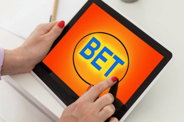 İnternetteki kumarhane. Genç bir kadın online bir oyunda bahis oynar. Bir kadın tablet üzerinde bahis oynar..