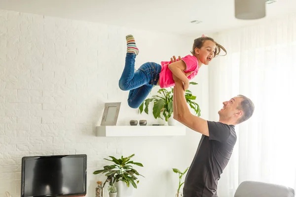 Вмію Літати Щасливий Тато Піднімає Свою Маленьку Доньку Стоячи Вітальні — стокове фото