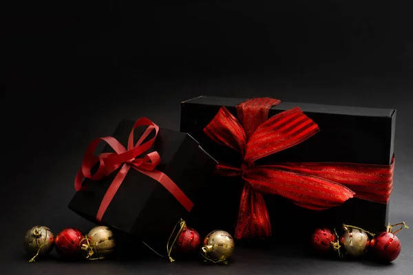 Schwarze Geschenkschachtel Kugeln Roter Weihnachtsschmuck Auf Dunklem Holzhintergrund Kopierraum — Stockfoto