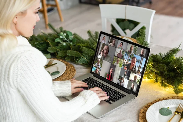 Virtual Christmas tree meeting team teleworking. Family video call remote conference. Laptop webcam screen view. Team meet working from their home offices. Happy hour party online woman.