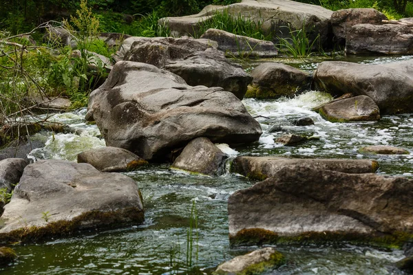 beautiful ripples on river flow over stones in summer.