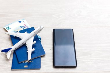 Mobil akıllı telefon, uçak ve çek defterinin görüntüsü beyaz arkaplanda izole edilmiş. İş teknolojisi gezisi ve seyahat, maaş çeki kavramı.