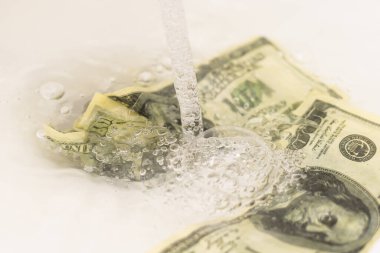 Kirli bir Amerikan yüz dolarlık banknot temizlik. kara borsada para. Erkekler lavabo su jetleri yakınındaki elinde 100 dolarlık banknotlar.