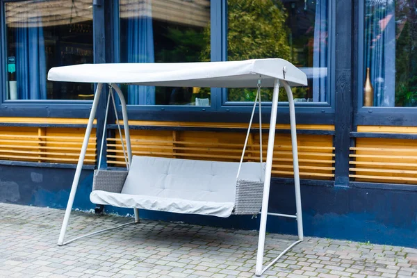 Outdoor white bench swing. Garden swing with roof. Sun shelter