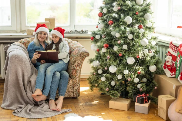 Güzel Genç Anne Noel Ağacının Yanında Kızına Kitap Okuyor — Stok fotoğraf