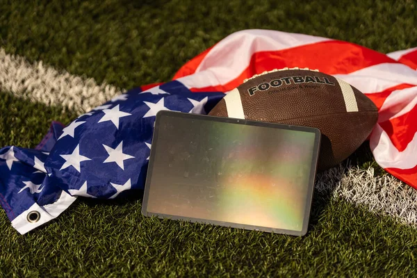 american football ball and tablet, american flag.