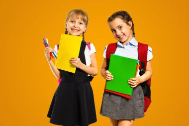 Little girls with books on orange background.