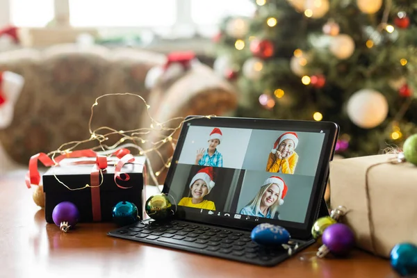 Big family singing christmas song at tablet camera during online video call. Smiling parents and children. Joyful family congratulating relatives with happy new year online.