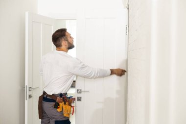 High Angle View Of Male Carpenter With Screwdriver Fixing Door Lock.