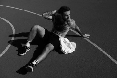 Eğitimden sonra kaslı ve formda adam dinleniyor.