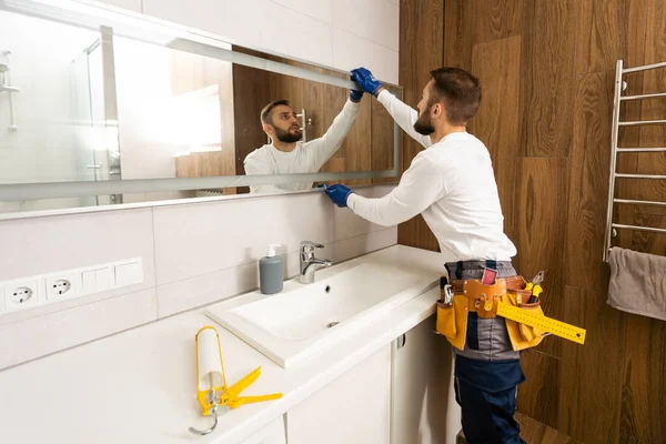 Der Arbeiter Montiert Den Spiegel Badezimmer — Stockfoto