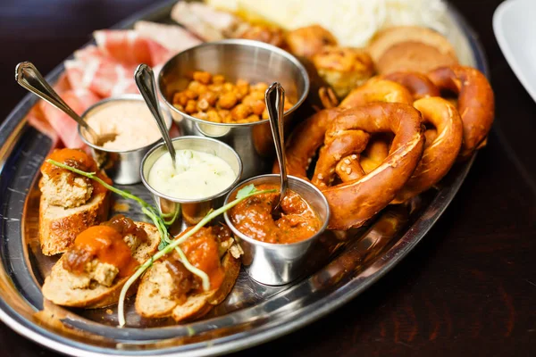 İtalyan antipasti şarap atıştırmalıkları masada. Kırmızı şarap bardakları, peynir çeşitleri, bruschetta, zeytin, prosciutto, açık hava partisi