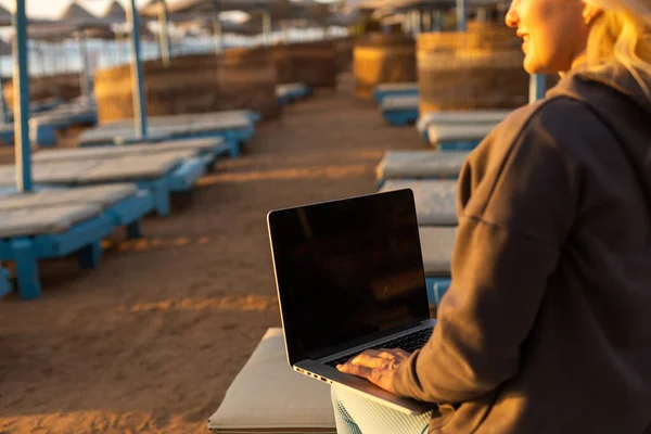 Γυναίκα Κάθεται Φορητό Υπολογιστή Στην Παραλία Καλοκαίρι Στο Ηλιοβασίλεμα — Φωτογραφία Αρχείου