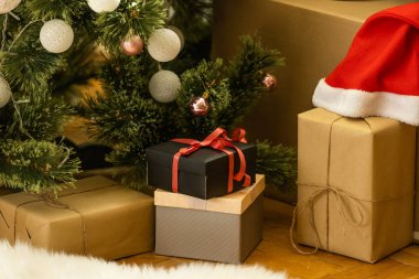 Oda da köknar ağacının yanında yerde duran güzel Noel hediye kutuları.