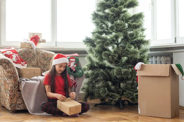 小さなかわいいです女の子見中の輝くクリスマスプレゼントボックス — ストック写真