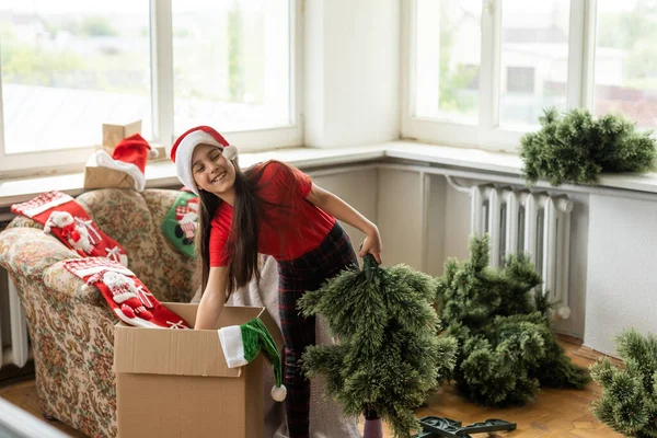 Little Girl Makes Artificial Christmas Tree Wear Santa Hat Indoors — Foto Stock