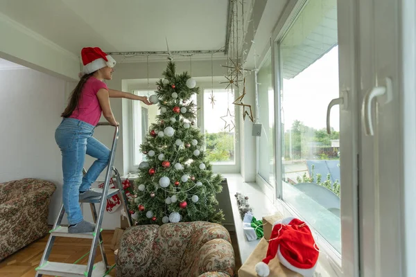 Kleines Mädchen Auf Einer Leiter Schmückt Den Weihnachtsbaum — Stockfoto