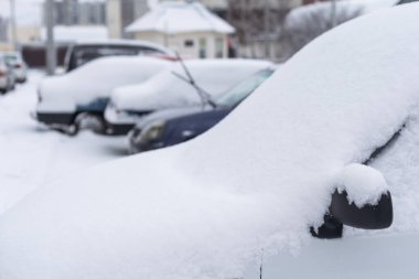 Car parked on street under winter snow fall.