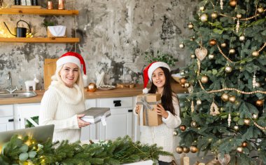 Anne ve kızının dostluğu ve sevgisi. Aile değerleri. Noel 'i kutlamaya hazırlanıyorum. Noel ağacı süslemesi. Anne ve kızı arasında iyi bir ilişki kurmak.