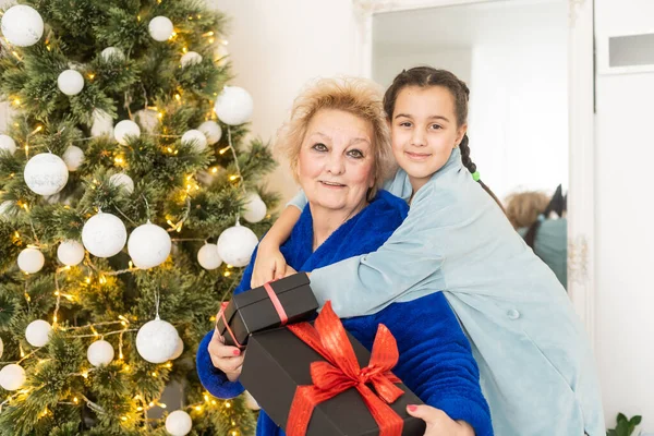 Happy Senior Woman Giving Christmas Surprise Little Girl Home Excited — Stok fotoğraf