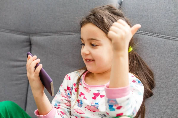 little child girl play on smartphone at home