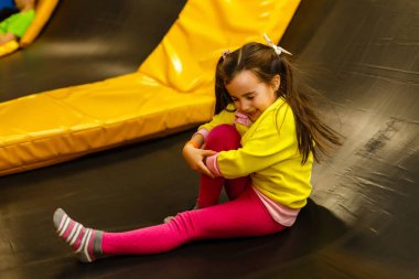 Çocuk yaralı. Çocuğun dizinde yakın çekim yarası var. Oyun odasında çocuk yaralanması