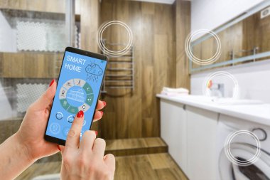 Akıllı bir evle ev ısısını kontrol etmek, telefonla yakın çekim yapmak. Evdeki akıllı aygıtları yönetmek için akıllı ev ve mobil uygulama kavramı.