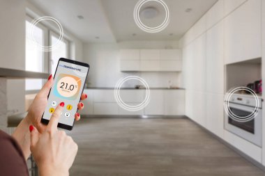 Ekranda akıllı ev yazılımı uygulaması olan cep telefonuna odaklan, dijital cihazlı kablosuz hafif müzik sıcaklık düzenlemesi, klima iklim kontrolü, iot, sanal asistan.