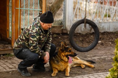 Alman çoban köpeğini eğiten bir adam..