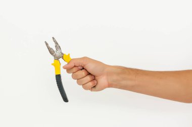 Tamircinin eli kesme yolları olan beyaz arkaplanda izole edilmiş bir kerpeten tutuyor.