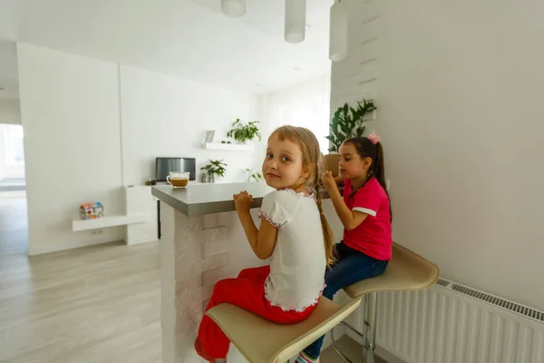 家にいてくれ 2人の幸せな子供たちは 屋内の白いリビングルームでリラックスした椅子に座っています 妹は家で楽しんでる — ストック写真