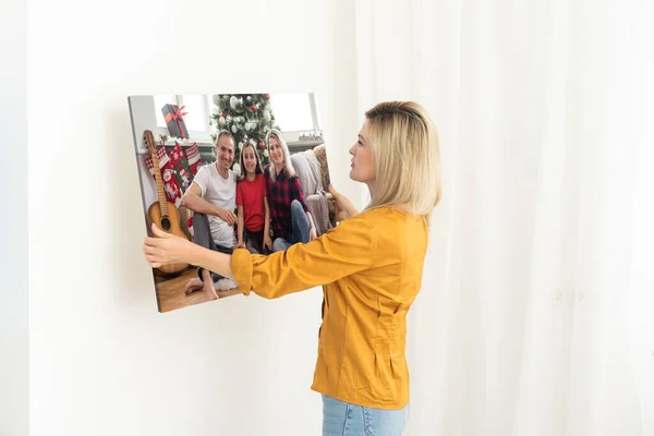 一个女人在画布上挂着一张圣诞节的照片 — 图库照片